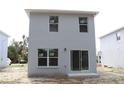 Rear elevation of a two-story home with sliding glass doors and three windows at 2222 E Emma Street, Tampa, FL 33610