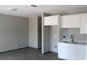 Modern kitchen featuring white cabinets, gray walls and floors with a sink at 2222 E Emma Street, Tampa, FL 33610