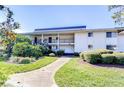 Two-story condominium complex with a walkway, black railings, and manicured landscaping at 29230 Bay Hollow Dr # 3274, Wesley Chapel, FL 33543