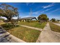 Charming single-story home featuring a well-manicured lawn and inviting landscaping in a residential neighborhood at 3298 Buckhorn Dr, Clearwater, FL 33761