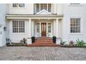 Home's stately front entrance featuring brick steps, white columns, and a wood door at 4610 W Browning Ave, Tampa, FL 33629