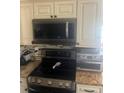 Kitchen featuring granite countertops, black stainless steel appliances, and ample cabinet space at 5086 Barrington Cir # 3201, Sarasota, FL 34234