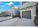 View of multiple townhomes with driveways and one-car garages at 5970 Grand Sonata Ave, Lutz, FL 33558