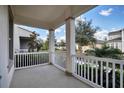 The covered porch has white railings and columns, offering a relaxing outdoor space with views of the neighborhood at 724 Winterside Dr, Apollo Beach, FL 33572