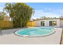 Backyard with a fenced in pool area and mature landscaping, perfect for relaxing outdoors at 10925 124Th Ave, Largo, FL 33778