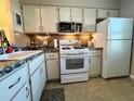 Efficient kitchen featuring white appliances, ample counter space and lots of cabinets at 1353 Mission Cir, Clearwater, FL 33759