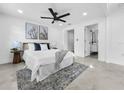 Bright main bedroom featuring a ceiling fan, neutral decor, and an en-suite bathroom at 2522 W North St, Tampa, FL 33614