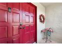 A vibrant red front door adorned with a welcoming wreath and stylish accents at 414 Windrush Bay Dr # 206, Tarpon Springs, FL 34689