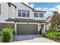 Charming two-story home showing a two-car garage, paver driveway, and beautifully landscaped front yard at 5095 San Martino Dr, Wesley Chapel, FL 33543