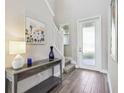 Bright foyer featuring wood floors, a staircase, decor, and a glass-paneled front door at 5095 San Martino Dr, Wesley Chapel, FL 33543