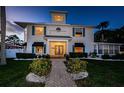 Stately home with a welcoming entryway, featuring blue shutters, a charming walkway, and lush landscaping at 614 Maryland Ave, Crystal Beach, FL 34681