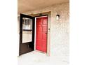 Close-up of a unit's front door with a storm door, featuring a vibrant red color and unique design at 6328 Newtown Cir # 28A1, Tampa, FL 33615