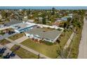 Aerial view of a single-story home featuring mature trees, a green roof and landscaping at 66 Kipling Plz, Clearwater Beach, FL 33767