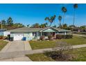 Charming single-story home with a well-manicured lawn and a red front door at 66 Kipling Plz, Clearwater Beach, FL 33767