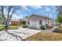 A detached single-car garage with a concrete driveway and tidy landscaping on a sunny day at 7048 68Th N St, Pinellas Park, FL 33781