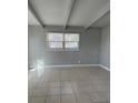 Bright living room with tiled floor and beam ceiling at 7908 Rideout Rd, Tampa, FL 33619