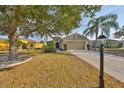 Attractive single-story home with lush landscaping, a covered entrance, and an attached two-car garage at 918 Regal Manor Way, Sun City Center, FL 33573