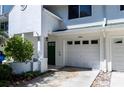 Close up of the exterior entrance with garage, porch, and a dark green front door at 9920 Indian Key Trl # 29, Seminole, FL 33776