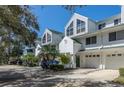 A row of white townhouses with garages, green roofs, and nice manicured front yards at 9920 Indian Key Trl # 29, Seminole, FL 33776