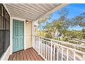 Balcony view showcasing a teal door, wood deck, and white railing at 1000 W Horatio St # 327, Tampa, FL 33606