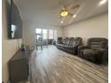 Bright living room featuring new floors, a ceiling fan, and a screened-in lanai at 11485 Oakhurst Rd # 1200-2, Largo, FL 33774