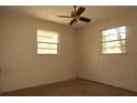 Cozy bedroom with two windows and neutral colored walls at 13924 Morgan St, Dade City, FL 33525