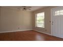 Bright living room featuring wood floors, a ceiling fan, and a large window at 13924 Morgan St, Dade City, FL 33525