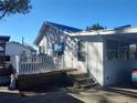 Rear exterior with a small deck, steps, and a partial view of a car, under a blue sky at 14124 Plum Ln, Hudson, FL 34667