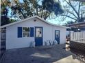 Garage exterior with two blue doors, a window with shutters, and a concrete area in front, for parking at 14124 Plum Ln, Hudson, FL 34667