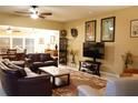 Comfortable living room featuring leather sofas, ceiling fan, tile floors, and decorative wall art at 2025 Grantham Greens Dr # 52, Sun City Center, FL 33573