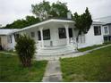 Inviting home showcasing a covered front porch with intricate white railings and landscaping at 2414 E 8Th Ave, Tampa, FL 33605