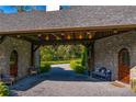 Covered entrance way featuring stone walls, wood accents, a gravel base, and outdoor seating at 3005 S Miller Rd, Valrico, FL 33596