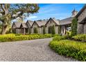 An estate home featuring stone facade, timber accents, meticulous landscaping, and a gravel drive at 3005 S Miller Rd, Valrico, FL 33596