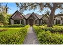 Charming home featuring a stone facade, timber accents, mature landscaping, and a stone walkway at 3005 S Miller Rd, Valrico, FL 33596