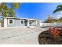 Blue and white home featuring a large concrete driveway and updated landscaping at 3213 W Cass St, Tampa, FL 33609