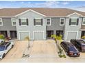 An aerial view of well-maintained gray townhomes with private garages, driveways, and manicured landscaping at 33065 Major Oak Dr, Wesley Chapel, FL 33545