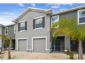 A well-maintained gray townhome with a garage, tidy landscaping, and an inviting entrance at 33065 Major Oak Dr, Wesley Chapel, FL 33545