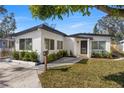 A beautifully landscaped home with a well-kept lawn, stylish mailbox, and a freshly painted white exterior at 3412 71St N St, St Petersburg, FL 33710