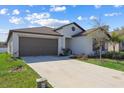 Well-maintained single-story home with gray trim, landscaped front yard and a two-car garage at 36642 Garden Wall Way, Zephyrhills, FL 33541