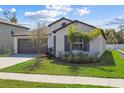 Beautiful one-story home featuring manicured landscaping, gray trim, and an attached two-car garage at 36642 Garden Wall Way, Zephyrhills, FL 33541