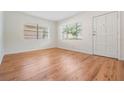 Inviting living room features hardwood floors, two windows with blinds, and a white door at 3908 W Laurel St, Tampa, FL 33607