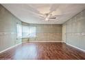 Bright and airy living room with wood flooring, decorative trim, and a modern ceiling fan at 411 Dolphin S Dr, Oldsmar, FL 34677