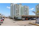 Exterior view of a tall condominium building with covered parking and well-maintained landscaping at 420 64Th Ave # 402, St Pete Beach, FL 33706