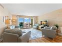 Comfortable living room featuring wood paneled walls, slider to balcony and ocean-themed decor at 420 64Th Ave # 402, St Pete Beach, FL 33706