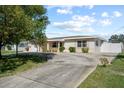 Scenic shot of a cozy home with a spacious driveway, lush lawn, and mature trees at 4435 34Th N Ave, St Petersburg, FL 33713