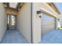 Inviting entrance featuring a covered front door and an attached two-car garage at 4911 Sienna Isles Ave, Wimauma, FL 33598