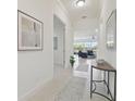 Bright hallway leads to a spacious living room with access to the screened lanai at 4911 Sienna Isles Ave, Wimauma, FL 33598