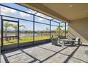 Relaxing screened-in patio offers comfortable seating and picturesque views of the pond at 4911 Sienna Isles Ave, Wimauma, FL 33598