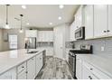 Modern kitchen with white cabinets, stainless steel appliances, subway tile backsplash, and wood-look flooring at 5134 Ballantrae Blvd, Land O Lakes, FL 34638