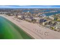 Expansive aerial view of a coastal community featuring a beach, ocean, and residential buildings on a sunny day at 5396 Gulf Blvd # 904, St Pete Beach, FL 33706